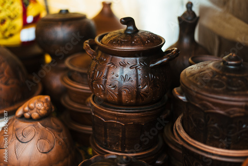 A lot of pottery at the fair. Ceramic national Russian dishes made. Burnt black ceramics. Burnt clay pots and plates, dishes