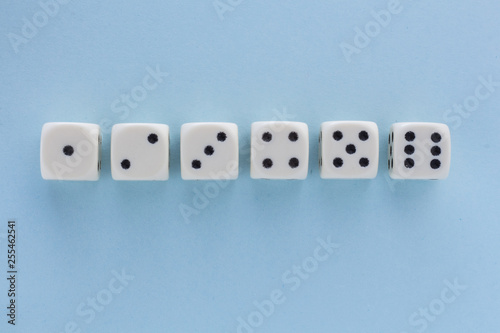 White gaming dices on light blue background. victory chance, lucky. Flat lay, place for text. Top view. Close-up. Concept gamble. spectacular pastel