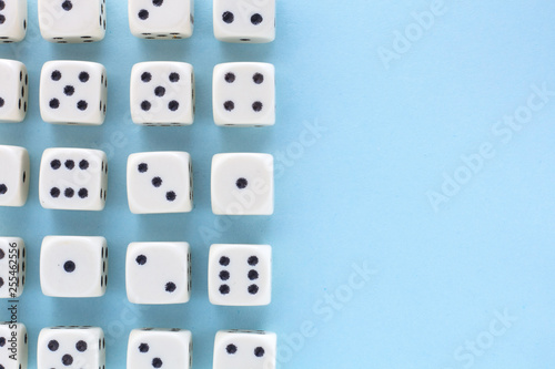 White gaming dices on light blue background. victory chance  lucky. Flat lay  place for text. Top view. Close-up. Concept gamble. spectacular pastel