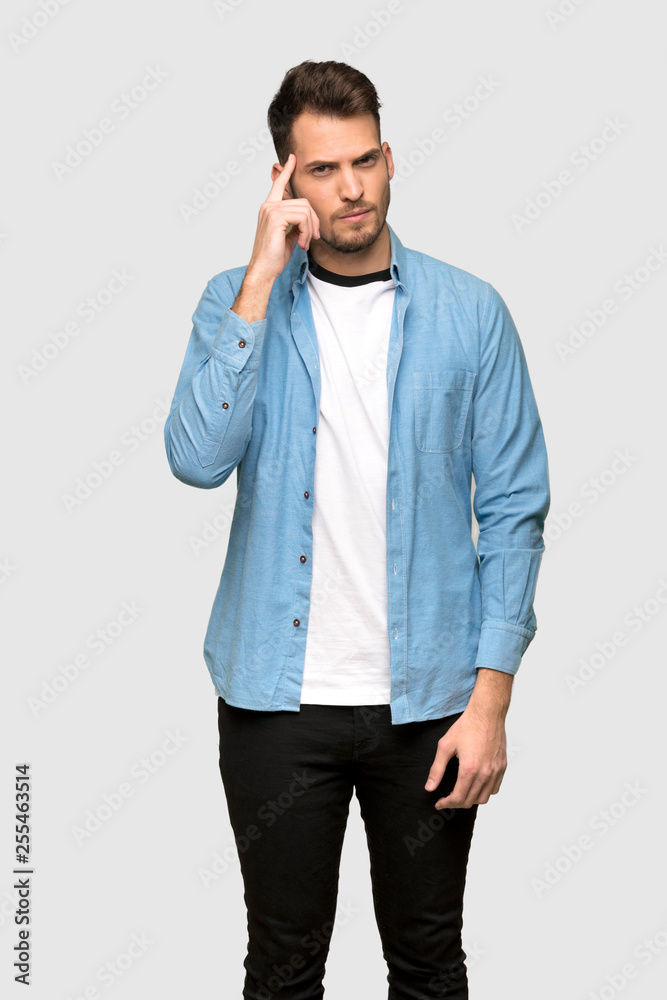 Handsome man having doubts and thinking over grey background Handsome man having doubts and thinking over grey background