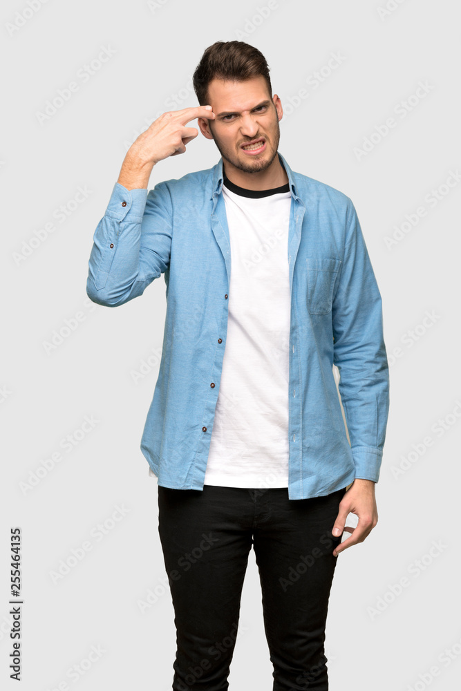 Handsome man with problems making suicide gesture over grey background Handsome man with problems making suicide gesture over grey background