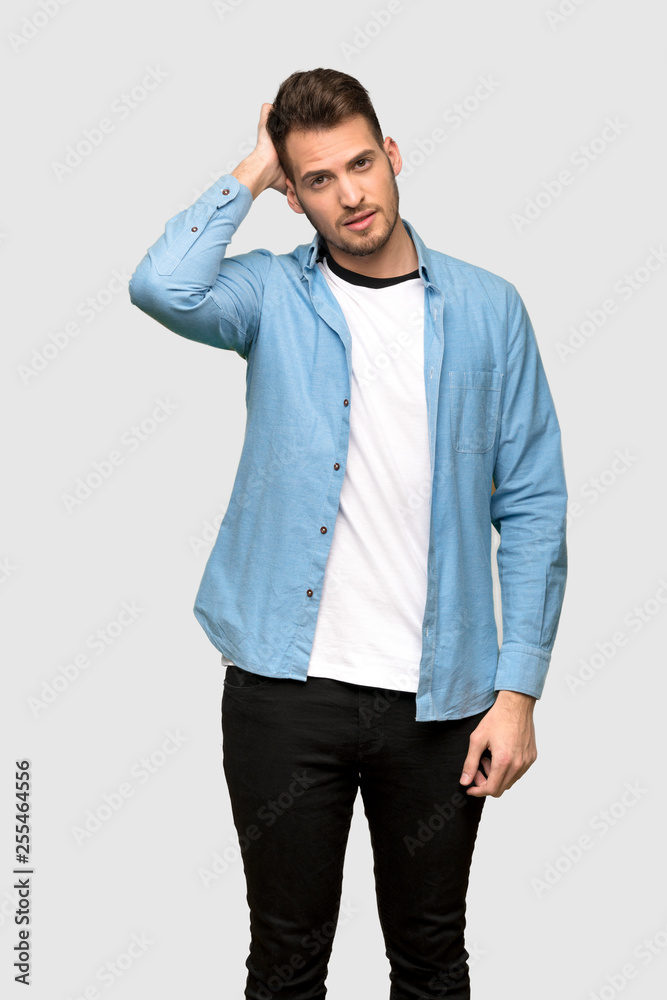 Handsome man with an expression of frustration and not understanding over grey background Handsome man with an expression of frustration and not understanding over grey background