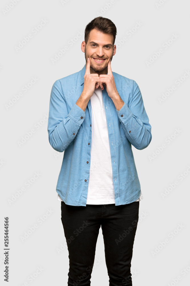 Handsome man smiling with a happy and pleasant expression over grey background Handsome man smiling with a happy and pleasant expression over grey background