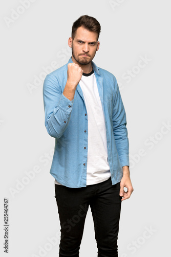 Handsome man with angry gesture over grey background