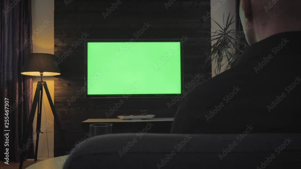 Green Screen - Man Watching TV in the Living Room. Over the shoulder shoot. Green Screen - Man Watching TV in the Living Room. Over the shoulder shoot.