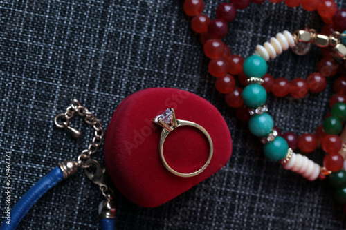 White gold diamond ring on top of colored stones. Romantic background ( Valentine's Day) 