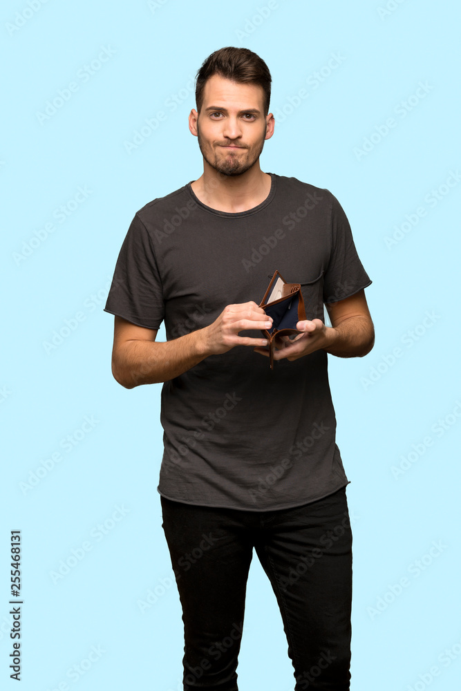 Man with black shirt holding a wallet over blue background Man with black shirt holding a wallet over blue background