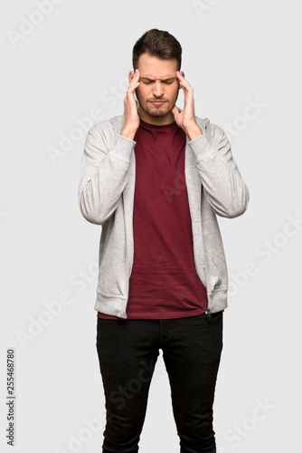 Man with sweatshirt with headache over grey background