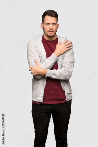 Man with sweatshirt freezing over grey background