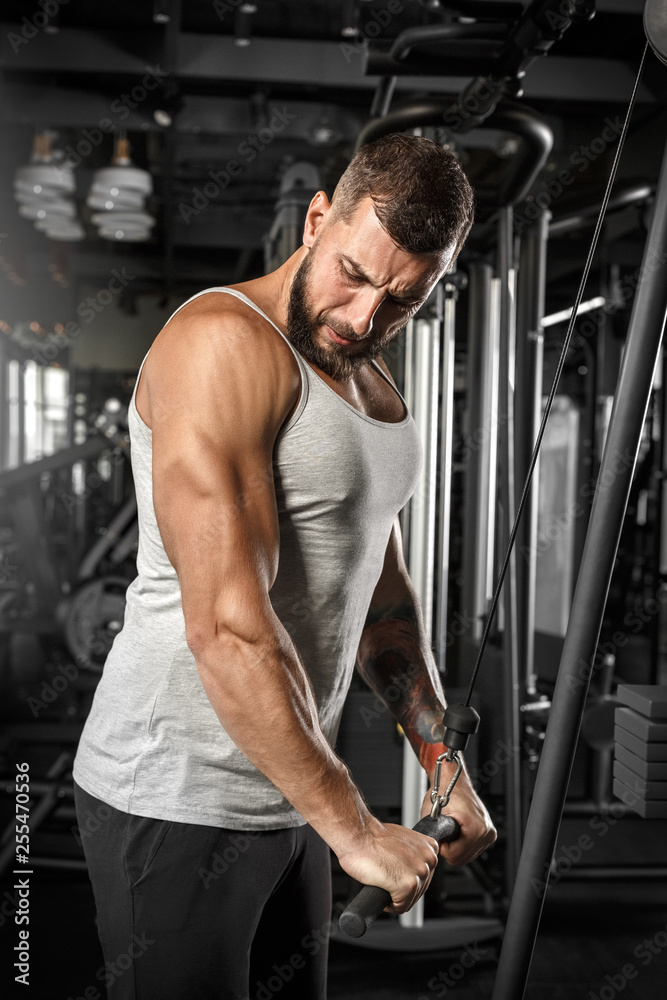 Bodybuilding. Bearded man standing doingcable straight arm pulldown at gym concentrated Bodybuilding. Bearded man standing doingcable straight arm pulldown at gym concentrated