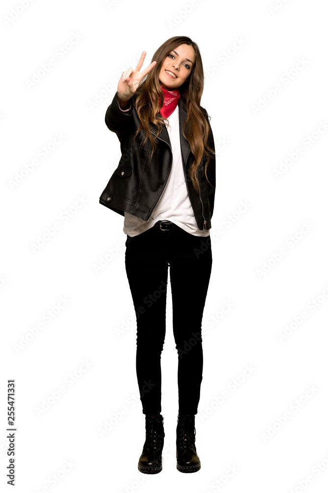 Full-length shot of Young woman with leather jacket smiling and showing victory sign on isolated white background Full-length shot of Young woman with leather jacket smiling and showing victory sign on isolated white background