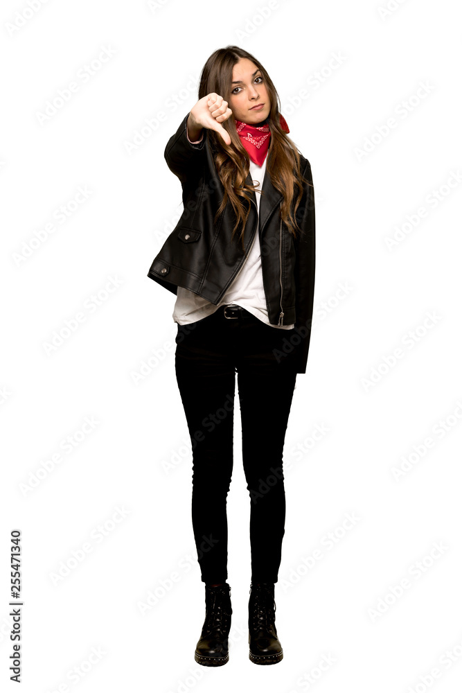 Full-length shot of Young woman with leather jacket showing thumb down sign with negative expression on isolated white background Full-length shot of Young woman with leather jacket showing thumb down sign with negative expression on isolated white background