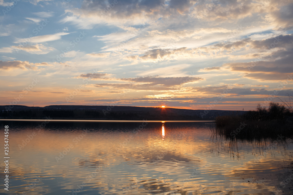 Landscape of pure spring sunset over lake.