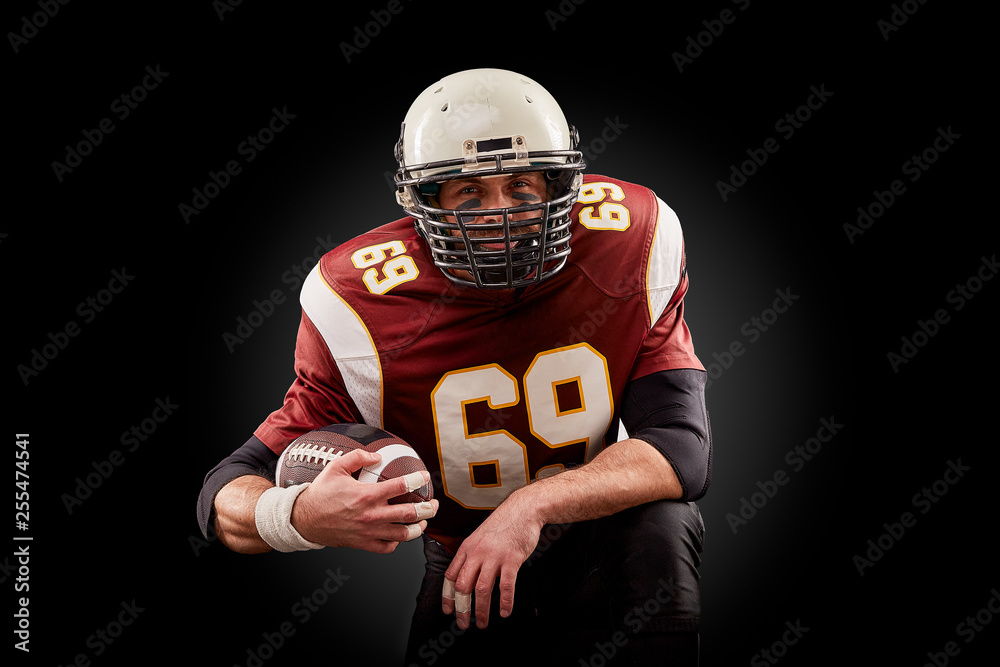 Portrait of American football player holding a ball with both his hands Portrait of American football player holding a ball with both his hands