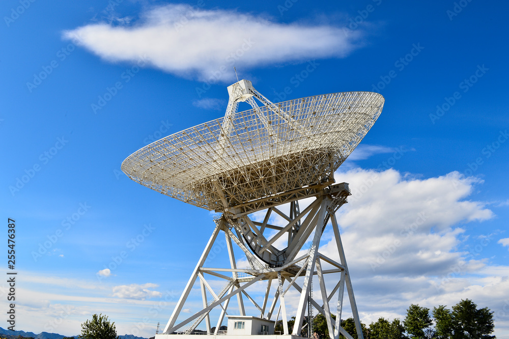 Array of satellite dishes or radio antennas against sky. Space o