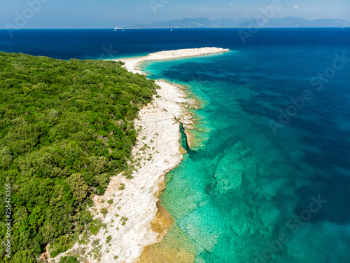 Aerial view of Emplisi Beach, picturesque stony beach in a secluded bay, with clear waters popular for snorkelling. Small pebble beach near Fiscardo town of Kefalonia, Greece. © MNStudio