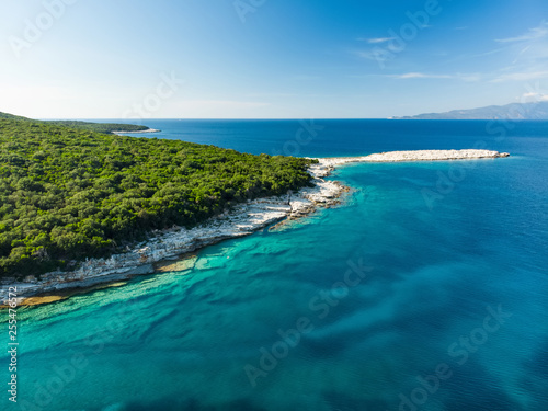 Aerial view of Emplisi Beach, picturesque stony beach in a secluded bay, with clear waters popular for snorkelling. Small pebble beach near Fiscardo town of Kefalonia, Greece.