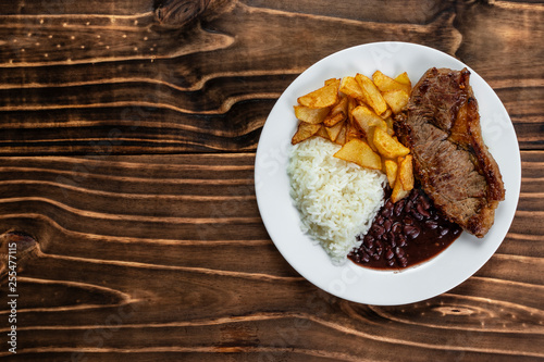 Canvastavla meal on white plate, rice, beans, steak and chips, Wooden Background