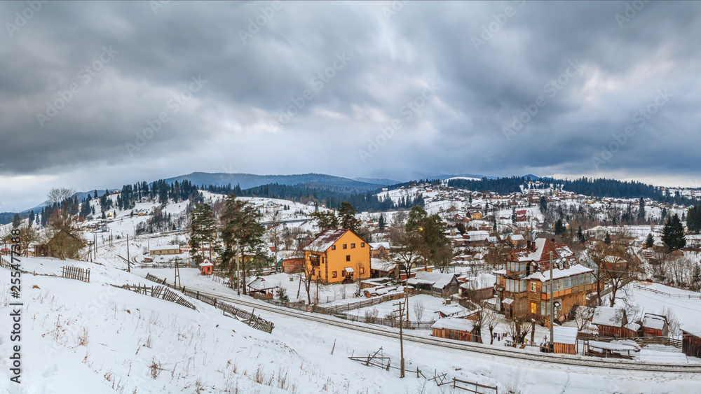 Rural winter landscape - view of the village Vorokhta with the railway in valley Prut River the Carpathian Mountains, in Ukraine