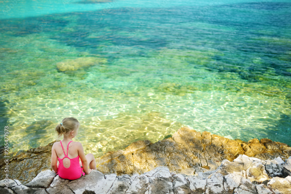 Cute little girl having fun at Emplisi Beach, picturesque stony beach in a secluded bay, with clear waters popular for snorkelling. Cute little girl having fun at Emplisi Beach, picturesque stony beach in a secluded bay, with clear waters popular for snorkelling.