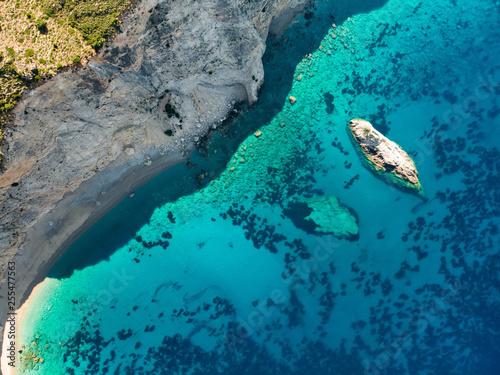 Scenic aerial top down view of picturesque jagged coastline of Kefalonia with clear turquoise waters, surrounded by steep cliffs.