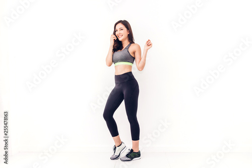Sport woman in sportswear relax stand after workout against copy space for adding text with white wall background.Diet concept.Fitness and healthy lifestyle