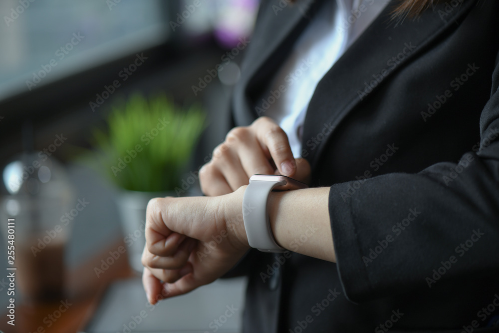Businessgirl are looking and using on the smartwatch.
