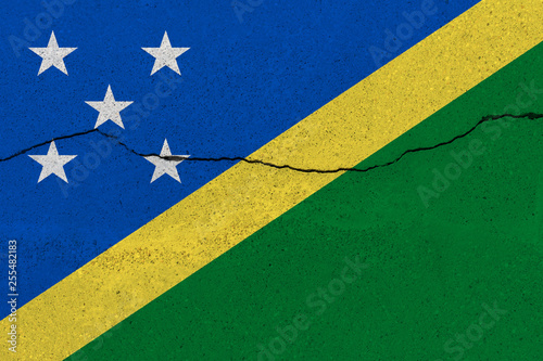 Solomon Islands flag on concrete wall with crack