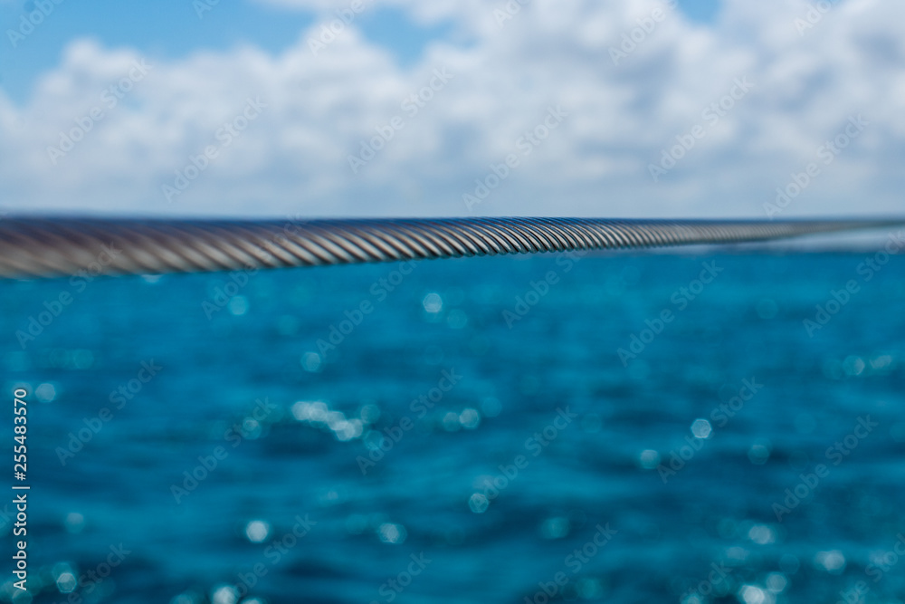 selective focus on metal cable. iron cable against caribbean sea background