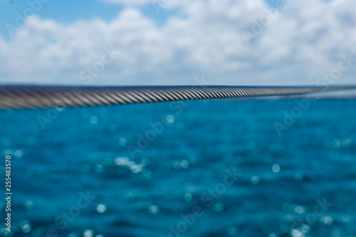 selective focus on metal cable. iron cable against caribbean sea background