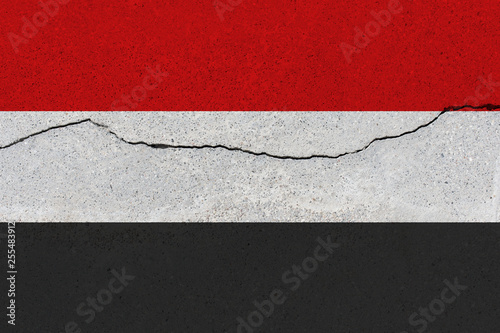 yemen flag on concrete wall with crack