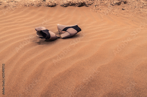 A pair of lost women shoes on the sand in the dunes
