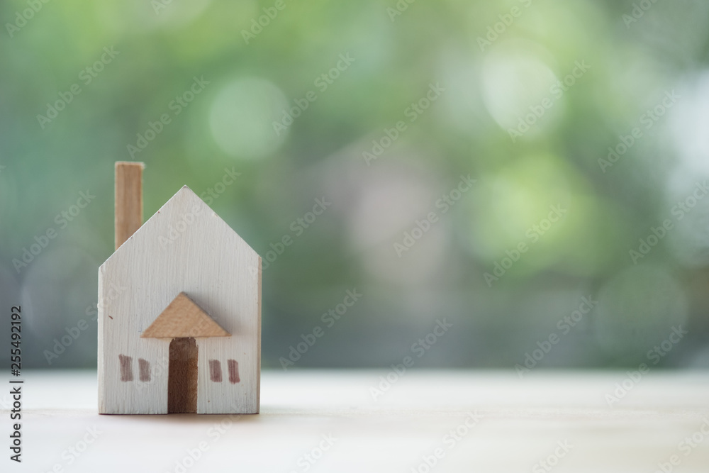 Miniature wooden toy house on nature background. Buying new house for family Miniature wooden toy house on nature background. Buying new house for family