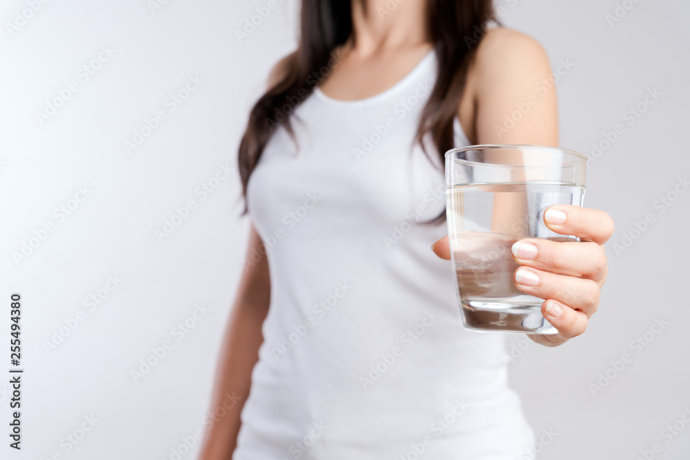 A glass of clean mineral water in woman's hands. Concept of environment protection, healthy drink and healthcare. A glass of clean mineral water in woman's hands. Concept of environment protection, healthy drink and healthcare.