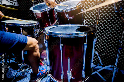 Foto man playing the drum set with wooden drumsticks and bass drum with foot in music