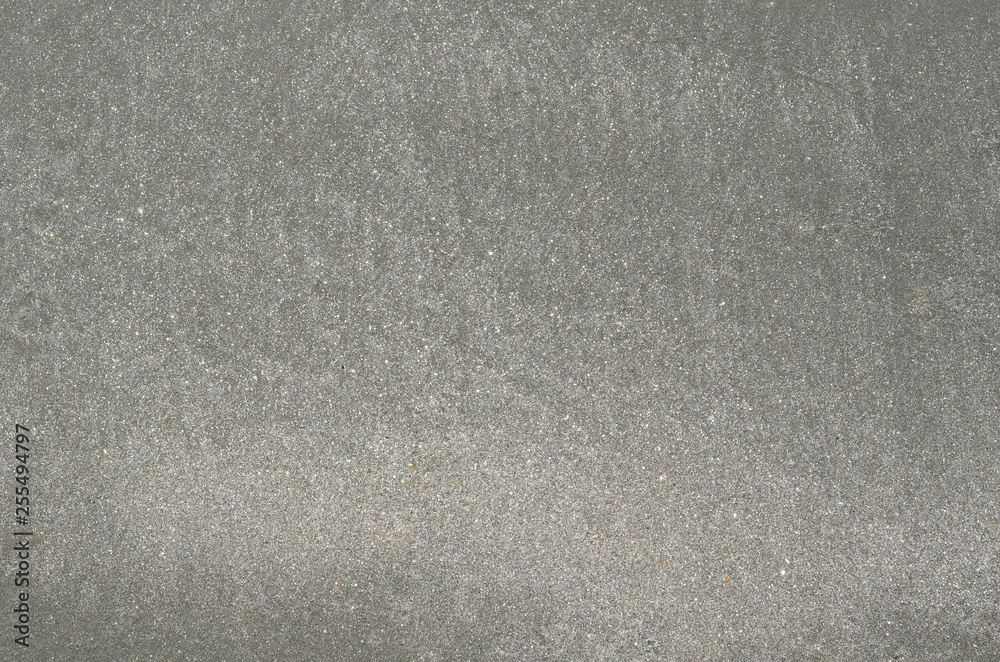 Background and texture photo of gray color wet sand from the sea on the beach.