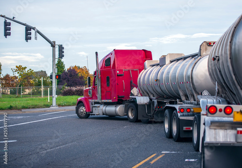 Red big rig classic semi truck transporting liquid chemicals in two specialized tank semi trailers