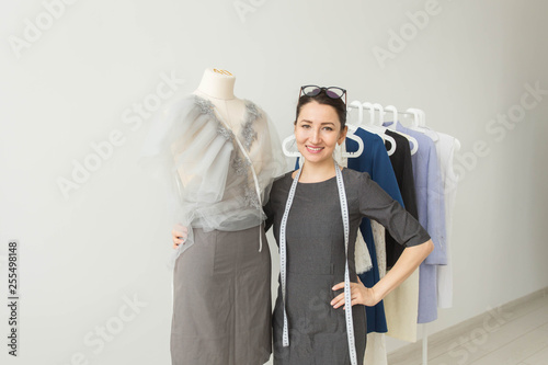 Dressmaker, fashion designer, tailor and people concept - Beautiful fashion woman designer standing in studio