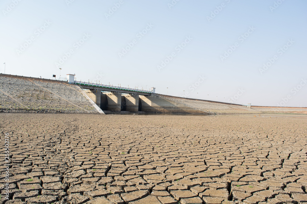 Naklejka A dried up empty reservoir or dam during a summer heatwave, low rainfall and dro