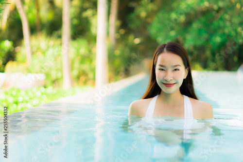Portrait beautiful young asian woman happy smile in swimming pool around resort and hotel © siraphol