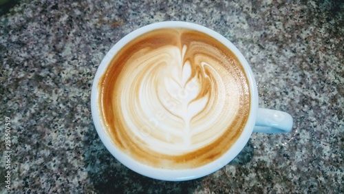 A cup of latte, cappuccino or espresso coffee with milk put on a wood table.