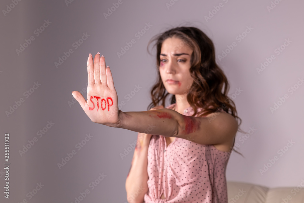 Domestic violence, protesting and people concept - brunette woman expressing denial with STOP on her hand on grey room Domestic violence, protesting and people concept - brunette woman expressing denial with STOP on her hand on grey room