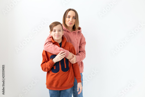 Mothers day, children and family concept - teen boy hugging his mom on white background with copy space