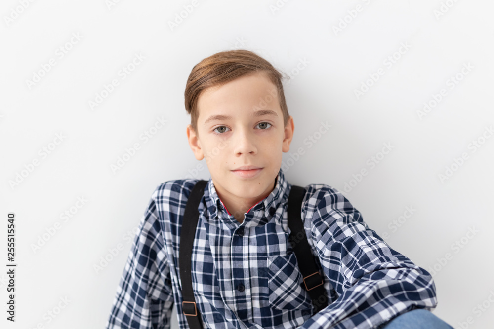 teenager, children and fashion concept - Portrait of kid dressed in plaid shirt posing over white background teenager, children and fashion concept - Portrait of kid dressed in plaid shirt posing over white background