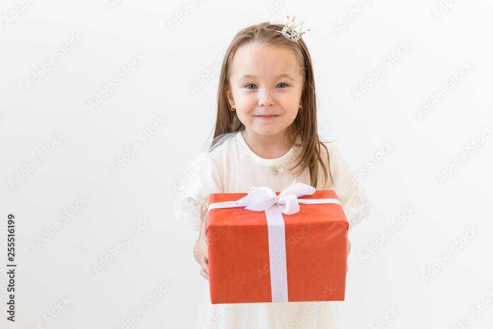 Holiday and presents concept - Little girl smile and holding red gift box Holiday and presents concept - Little girl smile and holding red gift box