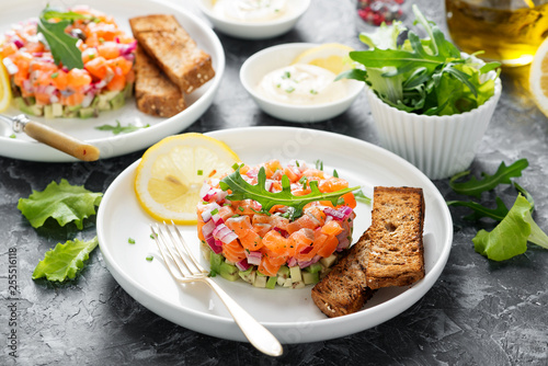 Salmon tartare with red onion, avocado, arugula and bread toast.
