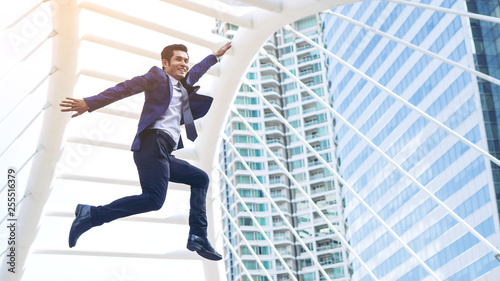 lifestyle business man feel happy jumping in air celebrating success and achievement on business district , business concept.