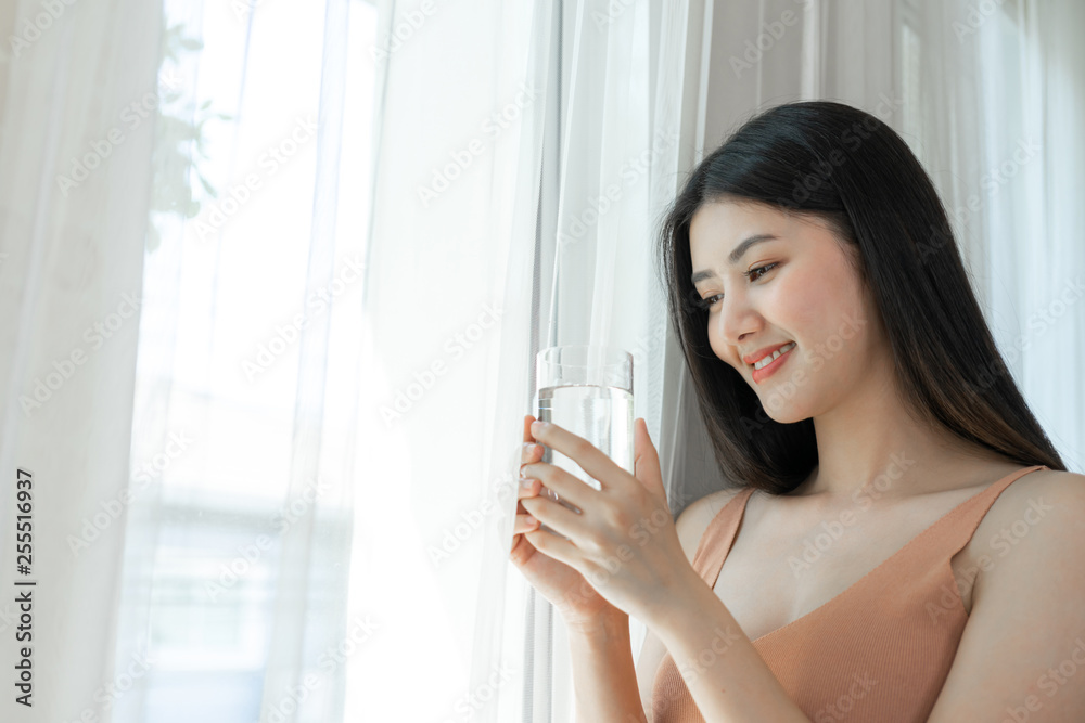 Beautiful beauty woman Asian cute girl feel happy drinking Clean drink water for good health in the morning , enjoying time in her home white bedroom background - lifestyle beauty woman concept Beautiful beauty woman Asian cute girl feel happy drinking Clean drink water for good health in the morning , enjoying time in her home white bedroom background - lifestyle beauty woman concept