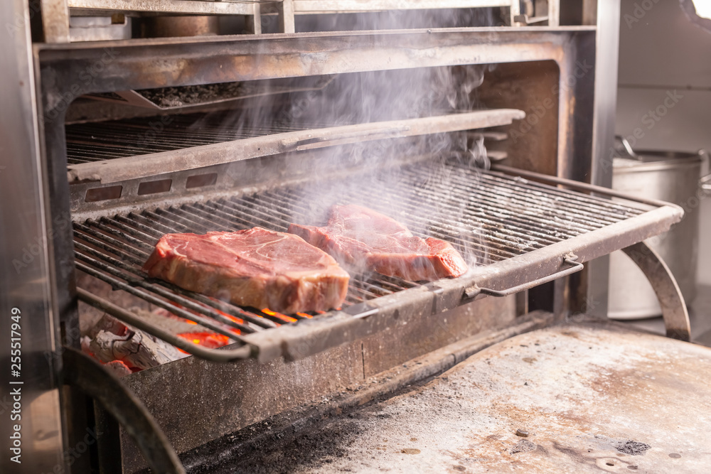 food, craft and delicious concept - cooking steak on a grill