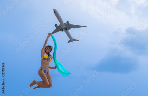 a Thai lady jumping to air plane for selfie at the back of Phuket airport.Mai Khao beach is close Phuket Airport .a lot of tourists like to selfie during the plane landing and take off on beach side.